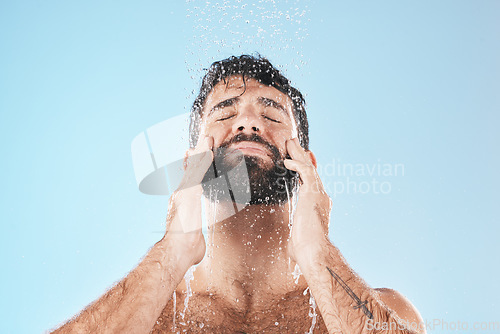 Image of Man, shower and face cleaning for skincare hygiene, body care wellness and grooming health in blue background studio. Water splash, facial spa dermatology and cosmetics beauty or washing in morning