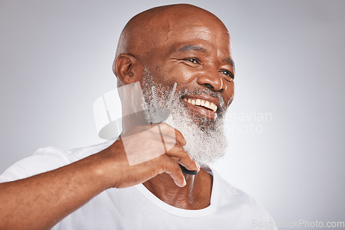 Image of Beard, beauty and shave with a senior black man grooming his facial hair in studio on a gray background while cutting. Happy, skin and face with a mature male using scissors to cut for shaving