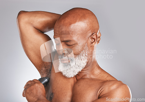 Image of Grooming, deodorant and armpit of a senior black man for shower care, hygiene and body health on a grey studio background. Clean, underarms and elderly African model with a product for fresh smell