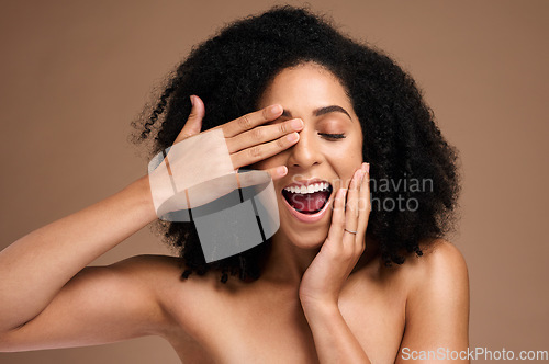 Image of Happy black woman, hair and face with surprise and fun, hands with manicure, healthy skin and glow. Natural curly hair, hair care and cosmetic care with facial skincare against studio background