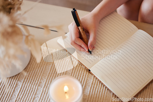 Image of Hand, candle and woman writing in journal with top view for calm, peace mindset and relax morning routine in home. Hands, notebook and diary planning goals, idea vision or creative writer lifestyle