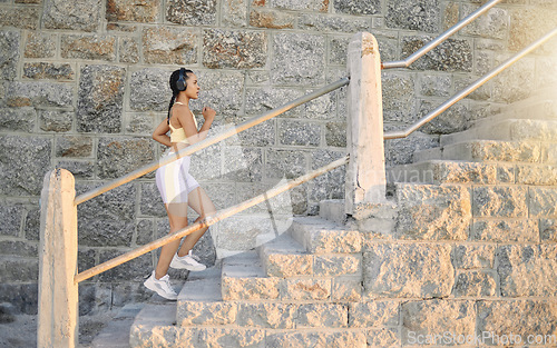 Image of Fitness, podcast or woman running on steps for cardio workout, training or body exercise at sunrise in summer. Brazil, wellness or girl athlete exercising or walking on stairs streaming radio music