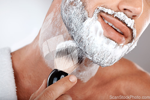 Image of Closeup, man and brush for shaving cream in studio for self care, grooming and facial hygiene with smile. Model, beard and foam for shaving, self love and cleaning for beauty, zoom and skincare