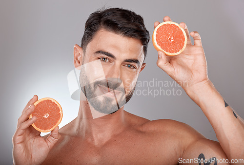 Image of Face portrait, skincare and man with grapefruit in studio isolated on a gray background. Wellness, nutrition and male model with fruit for healthy diet, facial care and vitamin c, minerals and beauty