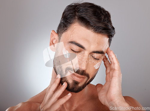 Image of Man, face and beauty with cream for skincare, moisturizer and skin lotion with cosmetics mockup against studio background. Grooming with hands for cosmetic care, facial treatment with wellness.