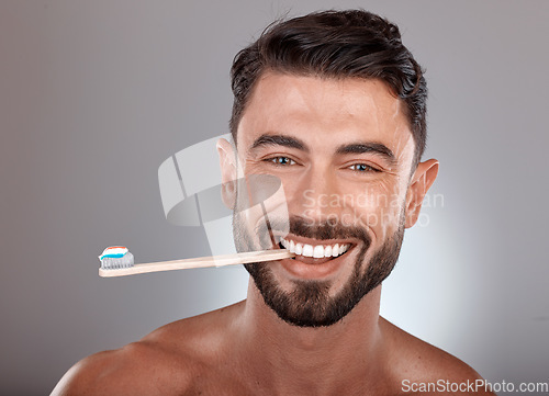 Image of Portrait, man and toothbrush with smile, wellness and on grey studio background. Dental hygiene, male or mouth health with toothpaste, fresh breath or brushing teeth for oral cleaning or healthcare