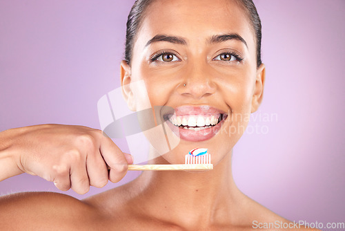 Image of Woman, smile and toothbrush in studio portrait with self care, beauty and toothpaste for hygiene. Black woman, teeth and cleaning with organic wood brush, happy and self love by purple background