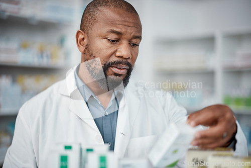 Image of Pharmacy, pharmacist and black man check inventory on shelf in shop. Wellness, healthcare products and male medical professional checking stock for medicine, medication boxes or pills in drug store.