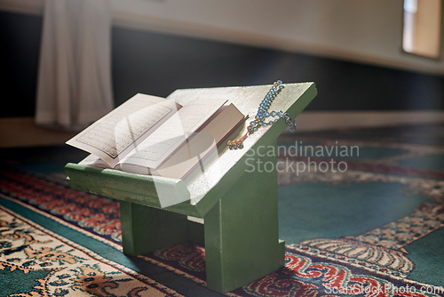 Image of Quran, prayer beads and mosque with an open book and a rosary in an empty holy room or temple ready for praying. Islamic misbaha, tasbih or sibha and scripture in a muslim place of worship for eid