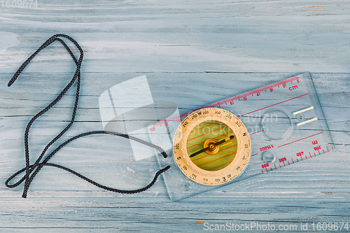 Image of Transparent plastic compass on wooden background
