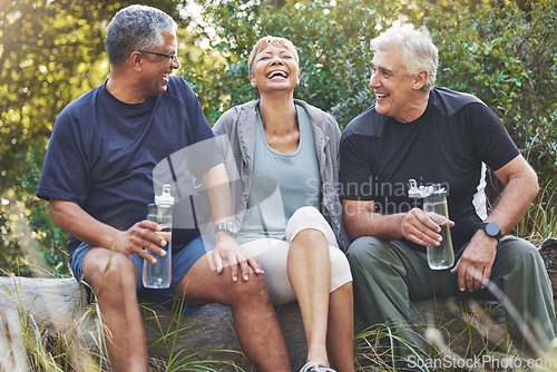 Image of Nature, fitness and senior friends in conversation while sitting in the forest after hiking. Happiness, communication and elderly people talking, bonding and drinking water after outdoor exercise.