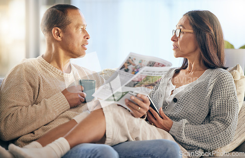 Image of Senior couple, newspaper and relax talking on sofa reading, morning conversation or quality time bonding together in living room. Elderly man, woman and news discussion, coffee and retirement peace