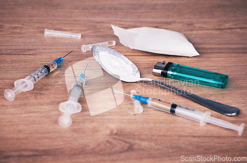 Image of Powder, syringe and drugs with spoon on table for alcohol addiction, drug rehabilitation and narcotics abuse. Medicine, illegal drug and addict problem for meth, cocaine and heroin solution on desk