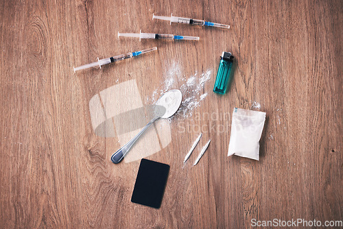 Image of Powder, syringe and drugs with spoon on table for alcohol addiction, drug rehabilitation and narcotics abuse. Medicine problem, crime and illegal drug habit with liquid, cocaine and heroin solution