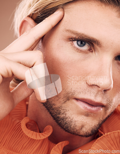 Image of LGBT, fashion and face portrait of man with orange clothes, beauty or creative style on studio background. Transgender, gay or non binary person with natural makeup, skincare glow or facial cosmetics