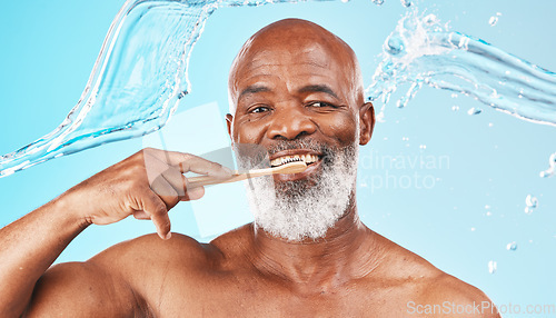 Image of Black man, dental hygiene and toothbrush with water, wellness and hygiene against blue studio background. Oral health, African American male and mature guy with smile, toothpaste and clean mouth.
