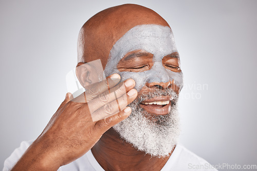 Image of Skincare, face or senior black man with cream marketing or advertising a luxury beauty product for self care. Studio background, cosmetics or African old man with a happy smile applying facial mask