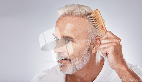 Image of Cosmetics, senior man and brush hair for grooming, treatment and on grey studio background. Mature male, elderly guy and comb for hair styling, luxury and beauty for wellness, retirement and fresh