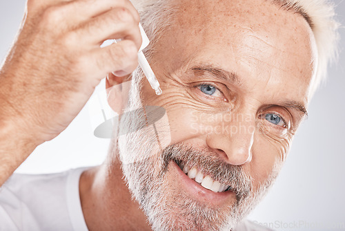 Image of Skincare, cosmetics and senior man with oil for face glow, beauty and marketing spa product on a studio background. Dermatology, wellness and portrait of an elderly model with serum for wrinkles