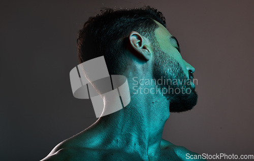 Image of Skincare, beauty and man with neon lights in studio for cosmetics, grooming and self care treatment. Creative art, design and blue lighting on male fashion model for satisfaction, wellness and style