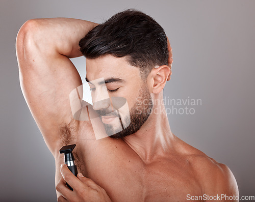 Image of Man, razor and armpit hair for skincare wellness, hygiene grooming and natural self care cosmetics treatment in grey studio background. Model, shaving and dermatology cleaning or hair removal routine