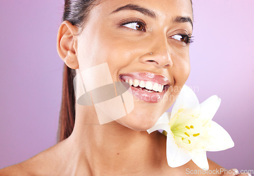 Image of Beauty, wellness and woman with a lily flower in studio for a health, cosmetic and natural face routine. Skincare, health and healthy girl model from Brazil with floral isolated by purple background.