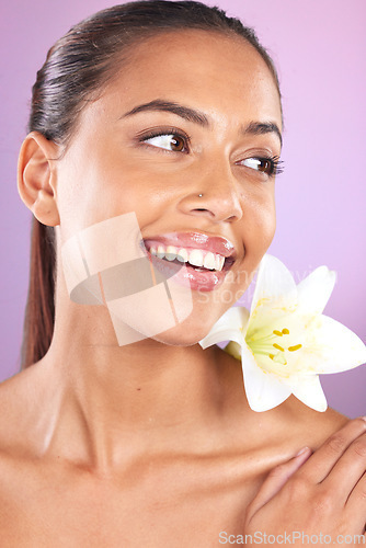 Image of Beauty, wellness and woman with a lily flower in studio for a health, cosmetic and natural face routine. Skincare, health and healthy girl model from Brazil with floral isolated by purple background.