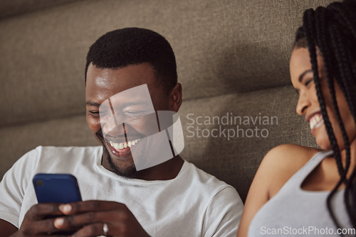 Image of Black couple, phone and relax happiness in bed for social media streaming, comic meme or quality time together reading online. African man smile, woman laughing and watching funny video on smartphone