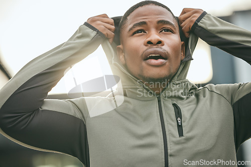 Image of Fitness, vision and hoodie with a sports black man getting ready for a workout, exercise or running. City, health and goal with a male athlete or runner outdoor in an urban town with motivation