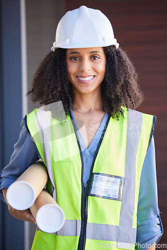 Image of Portrait, architect and blueprint with a black woman designer wearing a reflective vest and hardhat for construction. Building, architecture or safety with a female engineer holding plans indoors