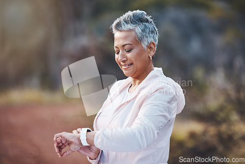 Image of Smartwatch, exercise and senior woman on nature trail for running, cardio and a fitness app workout. Elderly female with a watch in a forest to run for healthy lifestyle, body and energy with cardio