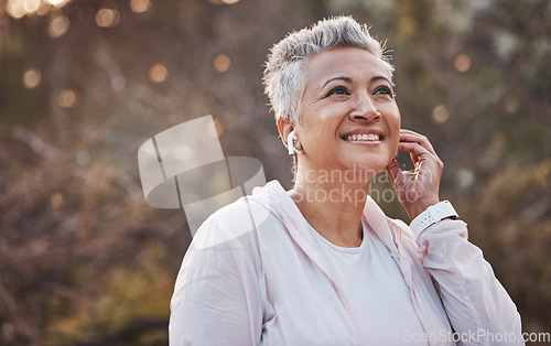 Image of Fitness, exercise and senior woman listening to music with earphones in nature while running for cardio workout outdoor. Elderly female with podcast in forest to run for healthy lifestyle and energy