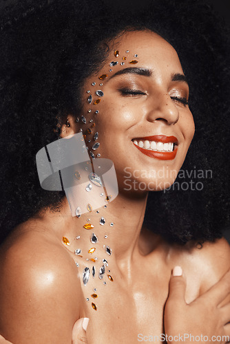 Image of Woman, face or body jewel rhinestones on black background studio for fashion sparkle, festival accessory or creative party crystals. Happy smile, afro beauty model and skin gems with makeup cosmetics
