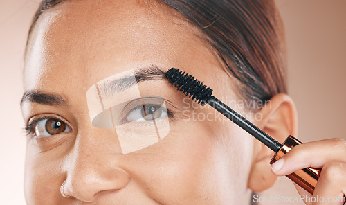 Image of Woman, brush eyebrows and makeup for beauty, cosmetic beauty or self care wellness by studio backdrop. Black woman, model and mascara eyes with cosmetics, skincare or application by studio background