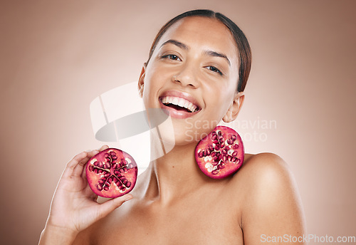 Image of Portrait, woman and pomegranate with natural product for skincare, healthy skin and cosmetic care wellness. Glow, shine and smile, vegan cosmetics and fruit facial treatment with studio background