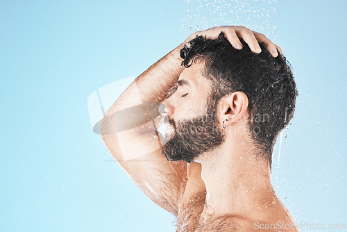 Image of Hair care shower, face and water splash of man in studio isolated on a blue background mockup. Water drops, skincare or profile of male model washing, cleaning or bathing for healthy skin and hygiene