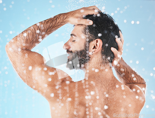 Image of Water, cleaning hair and man in shower with shampoo, conditioner and hair products on blue background. Hygiene, grooming and male profile washing body in bathroom for spa, wellness and hair care