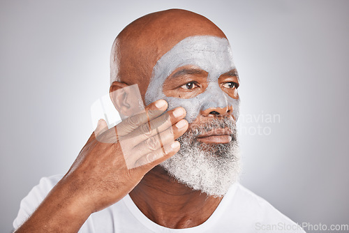 Image of Skincare, hand or old man with facial cream marketing or advertising a luxury beauty product for self care. Studio background, cosmetics or senior black man applying face mask for clean glowing skin