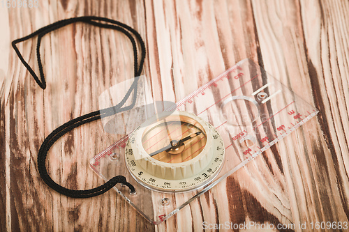 Image of Transparent plastic compass on wooden background