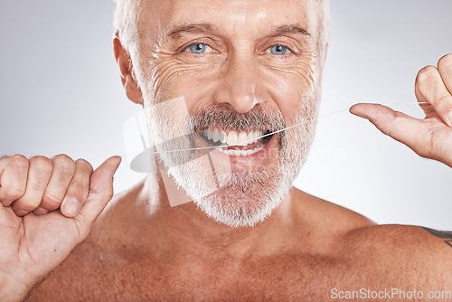 Image of Dental floss, portrait of man and teeth for wellness, healthy lifestyle and oral hygiene on studio background. Happy male face, flossing tooth and cleaning mouth, beauty cosmetics and facial smile