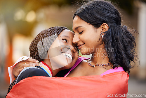 Image of Love, hug and happy lesbian couple at a freedom, equality or LGBTQ festival, event or parade. Happiness, smile and gen z interracial gay women embracing, hugging and bonding together in the city.