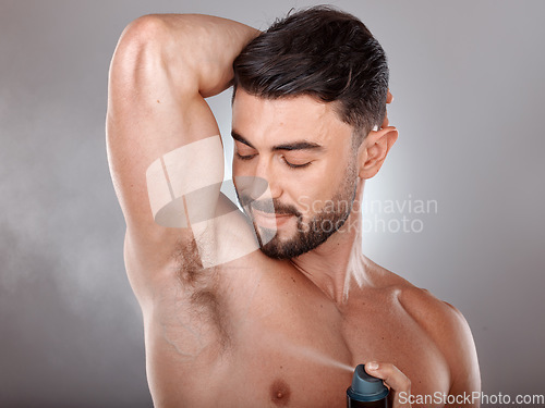 Image of Spray deodorant and man happy with product for armpit hygiene, grooming and cosmetic campaign. Body care, wellness and skincare model with healthy skin glow in gray studio background.