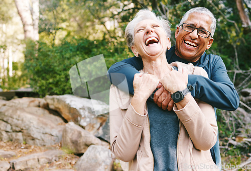 Image of Hiking, laugh and romance with a senior couple hugging while in the woods or nature forest together in summer for a hike. Fun, joke and bonding with a mature man and woman enjoying retirement outdoor