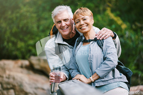 Image of Nature, hiking and portrait of a senior couple relaxing while walking in a forest for exercise. Love, happy and elderly people with a smile sitting to rest while trekking together in the woods.