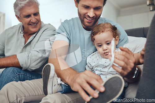 Image of Family, love and dad with child on sofa to tie shoes laces enjoying weekend, quality time and bonding together. Family home, support and grandfather, father and boy relaxing on couch in living room