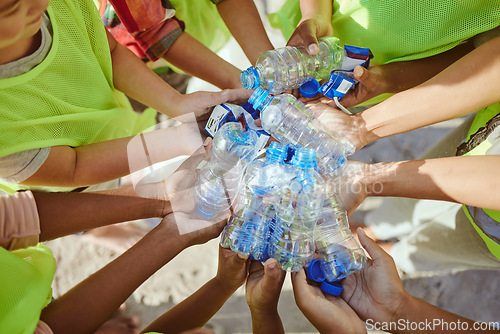 Image of Children, hands and plastic bottles in beach waste management, community service or climate change volunteer. Kids diversity, teamwork and trash cleaning, environment sustainability or nature recycle