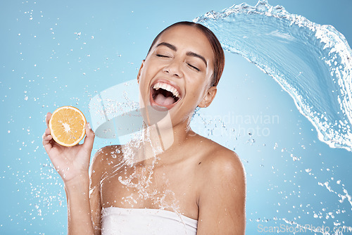 Image of Water splash, beauty and woman, clean with orange for organic cosmetic care and hygiene in shower. Water, fruit and vegan skincare treatment with splash and excited female against studio background