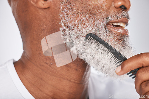 Image of Elderly, black man with comb for beard, beauty and grooming closeup with face hygiene and cosmetic care profile. Hair care, brush body hair and treatment with cosmetics against studio background