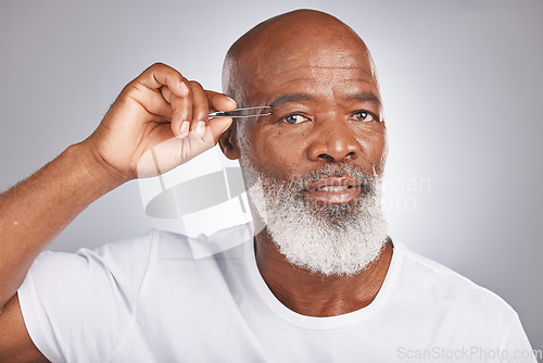 Image of Senior black man, eyebrow and tweezer for self care and grooming for clean, glow and fresh skin and face. Portrait of African male for facial hair removal or epilation on grey studio background