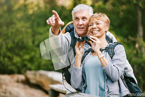 Image of Elderly, couple hiking and bird watching with adventure outdoor, hike together and fitness for active lifestyle. Nature, trekking and senior man pointing and woman with binocular, freedom and travel